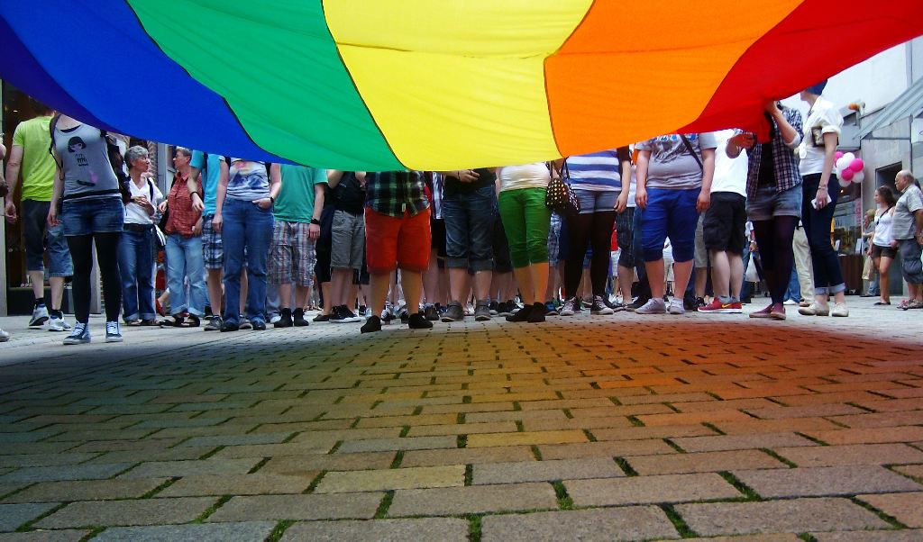 Menschen hinter einer Regenbogenfahne